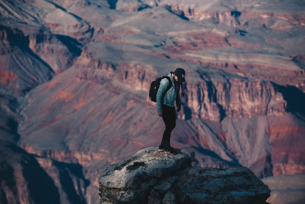 a man with a backpack standing on a rock