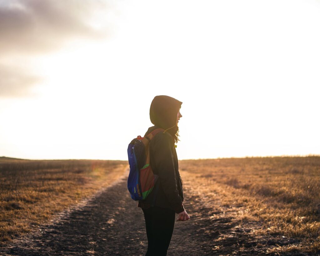 a woman with a backpack during sunset