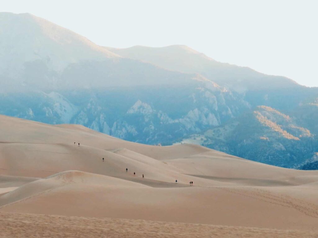 a view of people walking across the Sand Dunes 