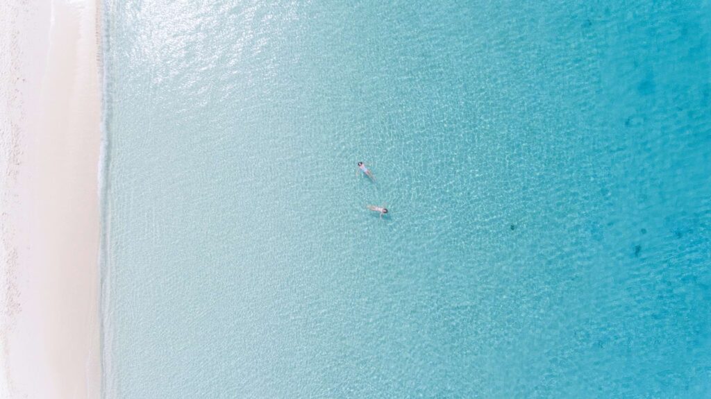 aerial view of people swimming in clear sea in Cayman Islands