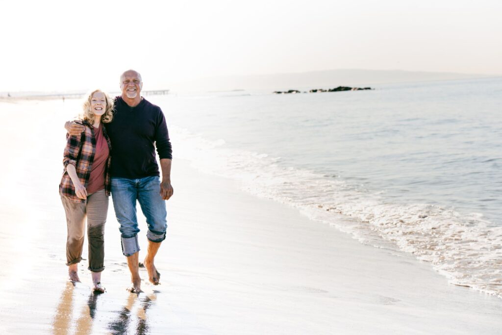 elderly couple walking on a beach