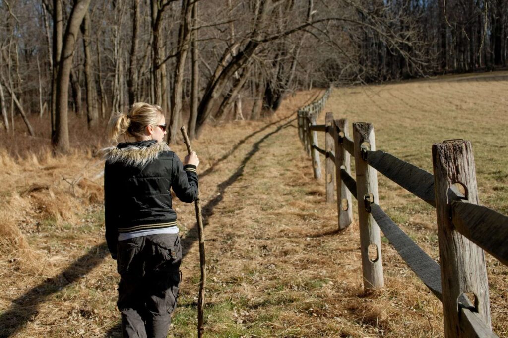 a woman hiking holding a stick