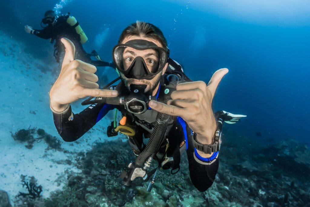 a scuba diver is posing in front of a camera in  a deep, blue water 